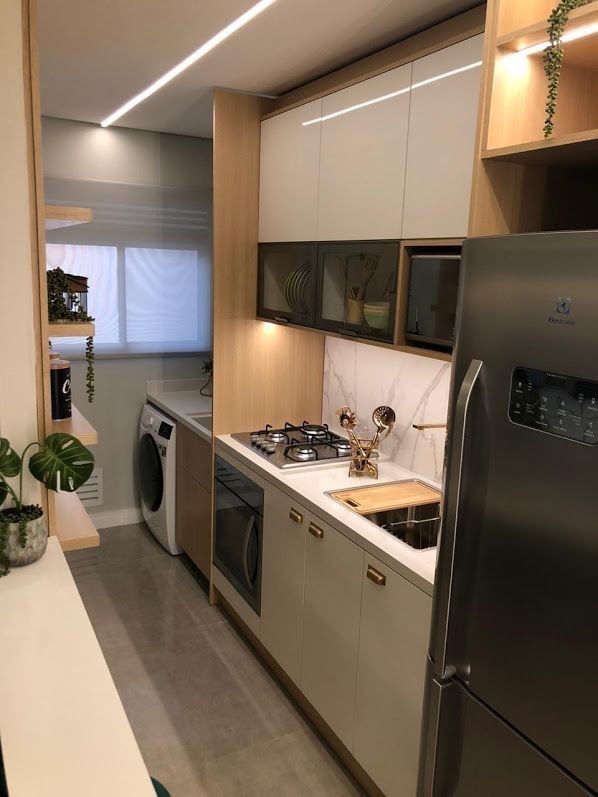 Detalhe de acabamento de cozinha planejada com puxadores dourados e bancada de mármore